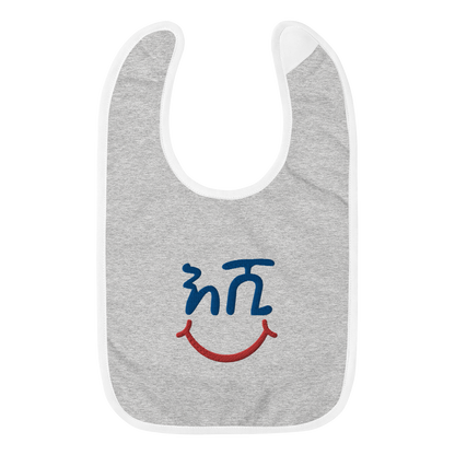 A baby bib that reads the Amharic wrod Eshi